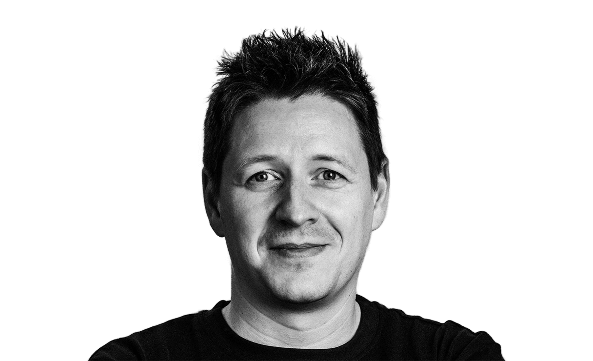 Michael Ehrich, black-and-white portrait, slightly smiling and looking at the camera.